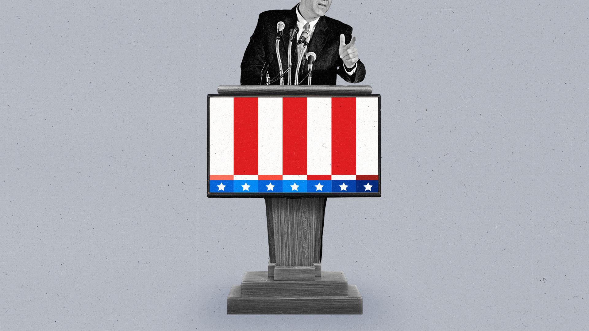 A man in a suit speaks into microphones on a podium that displays a connected TV with a red, white and blue test pattern.