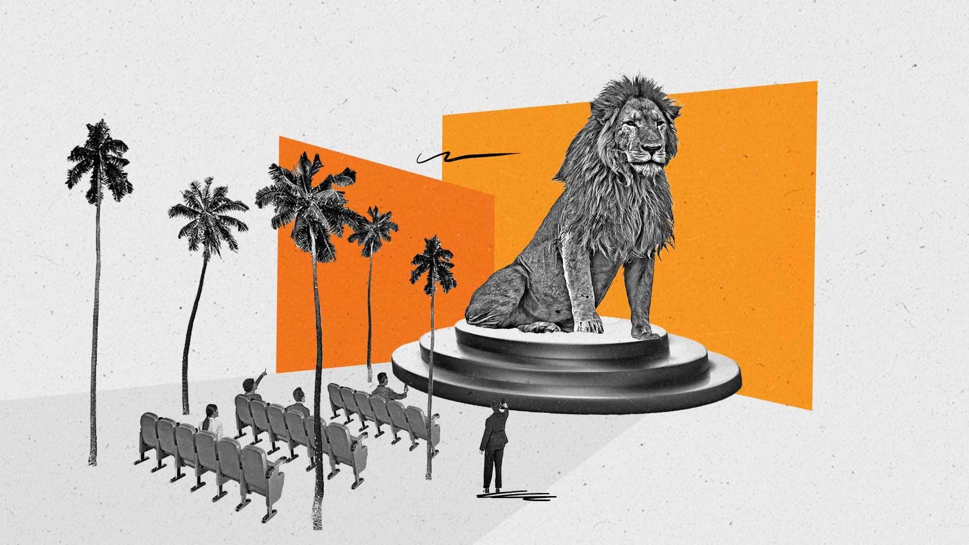 Rows of seats face an oversized lion on a pedestal as people look on.