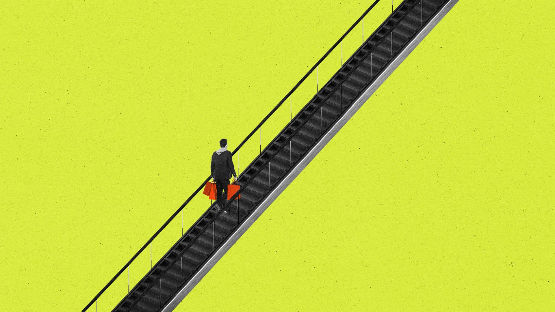An escalator on a yellow background going across the image, with a person holding bright red shopping bags riding up.