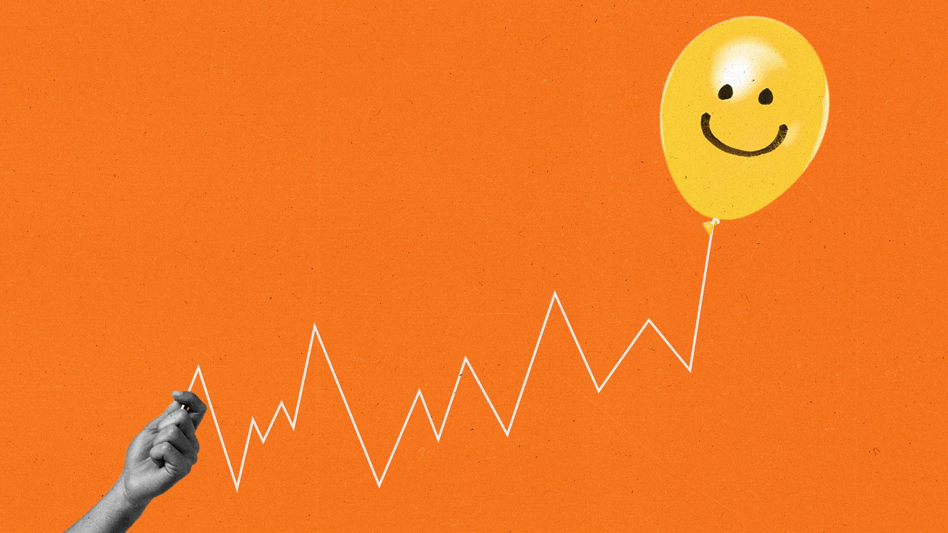 Hand holds balloon with a smiley face on it attached to a string that gradually goes upward.