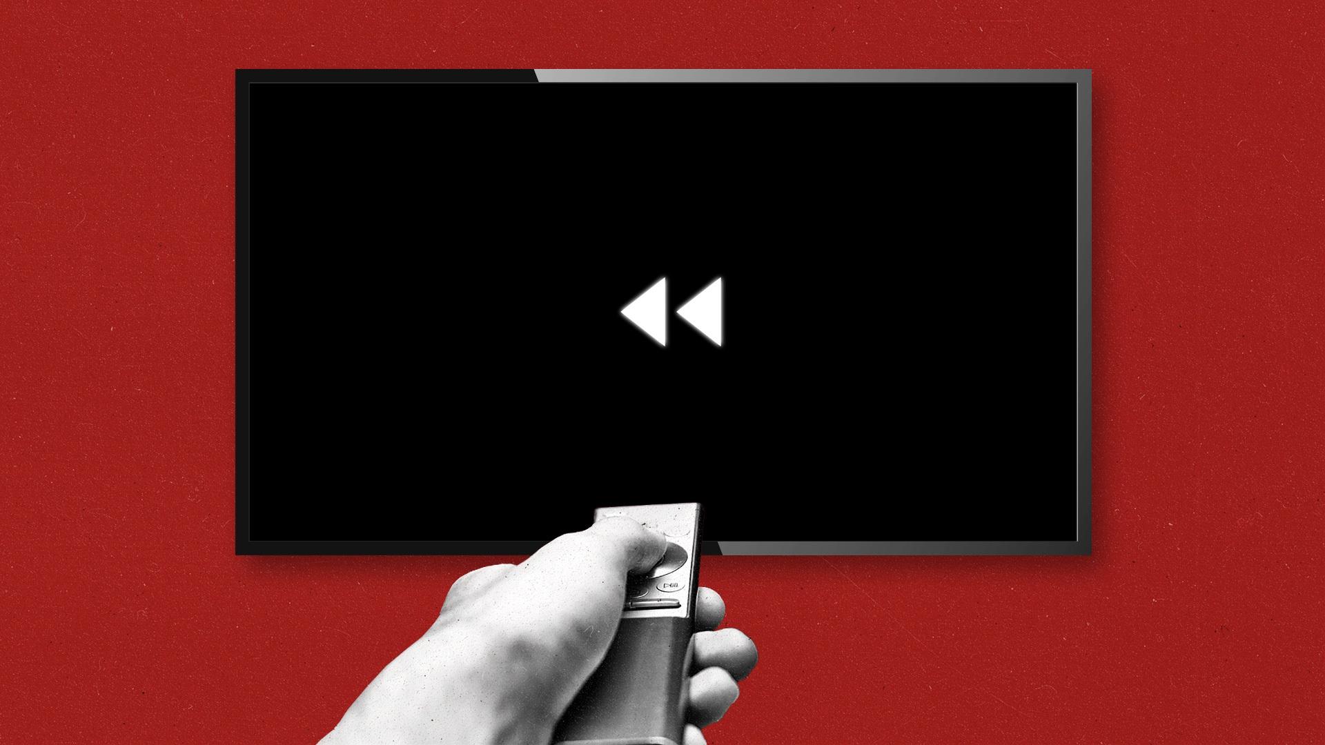Hand holding a TV remote rewinds a black TV screen on a red wall.