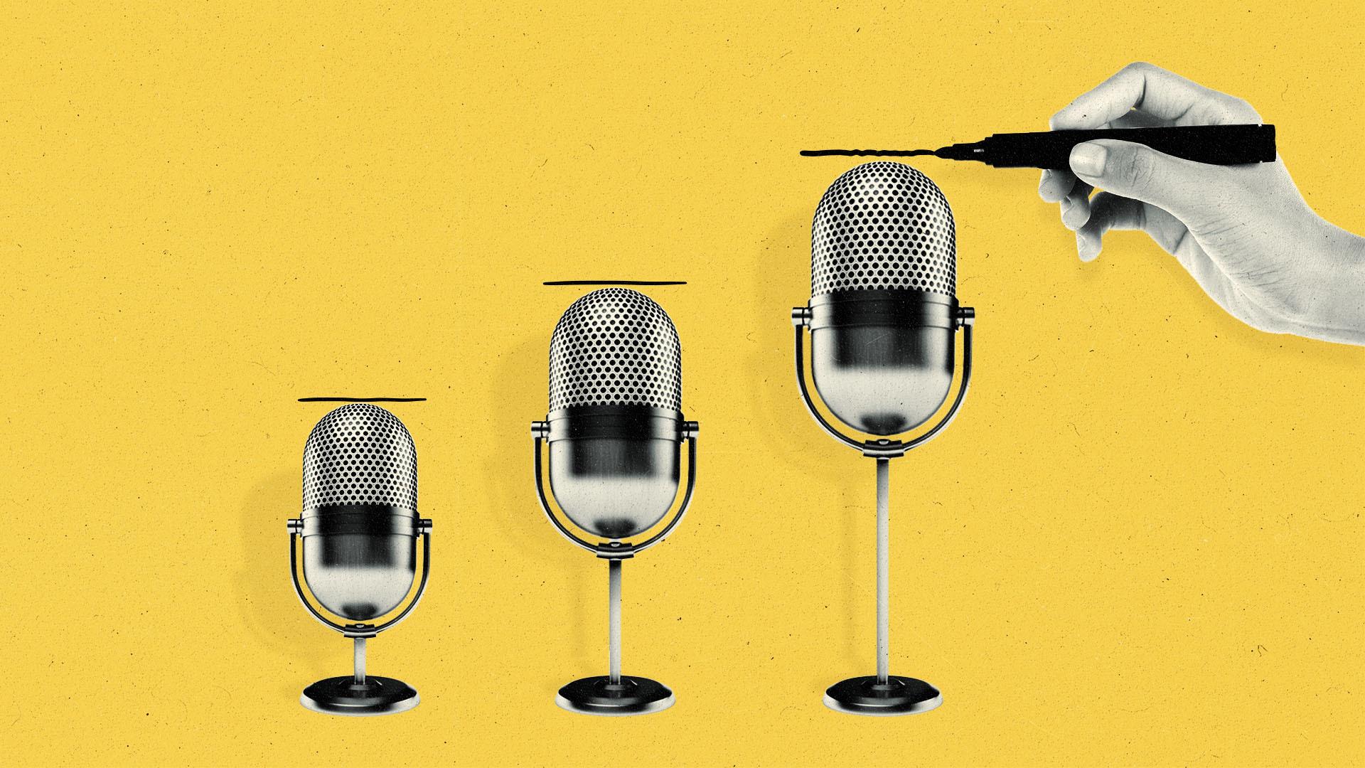 Three podcast microphones in increasing height are marked off by a hand against a wall.